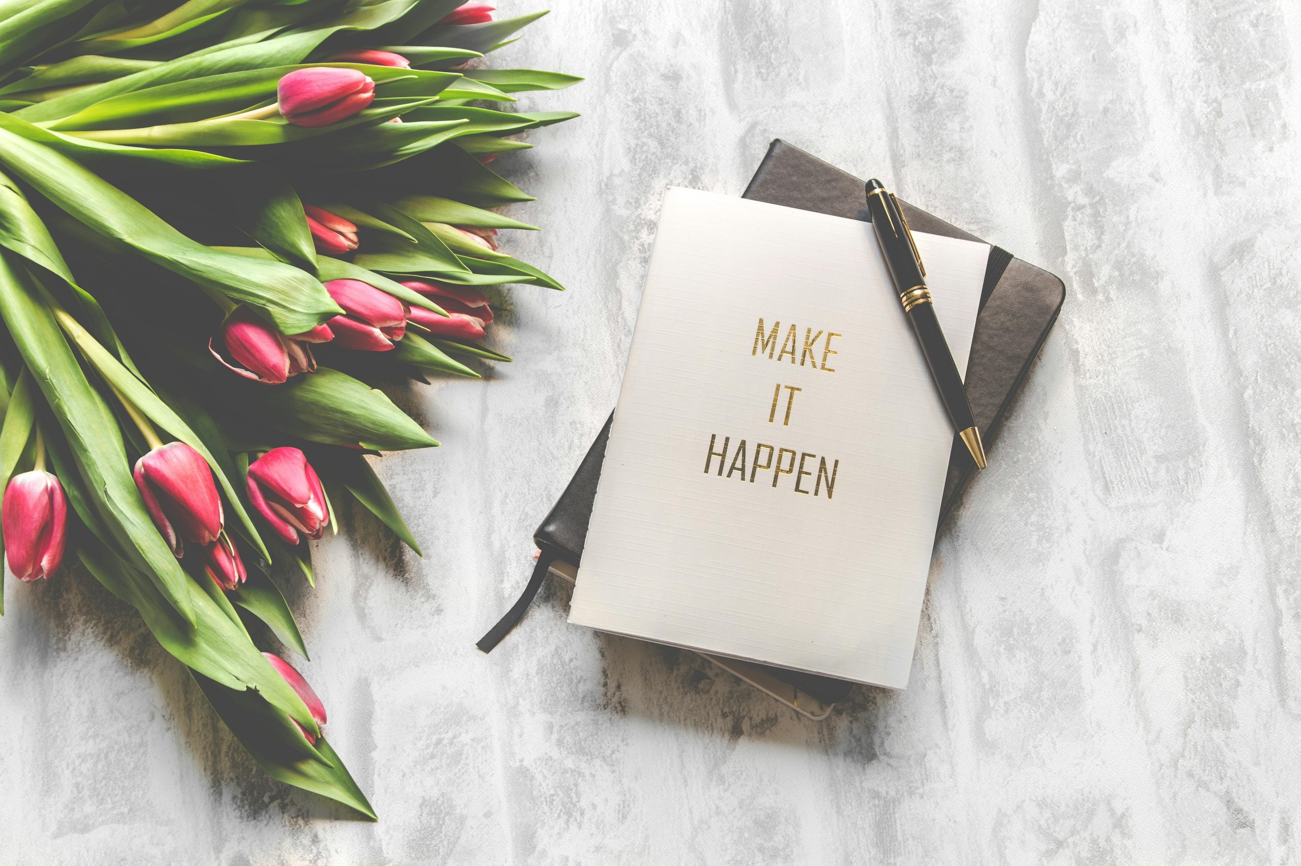 A clean desk with a planner and fresh flowers for a Monday reset routine.
