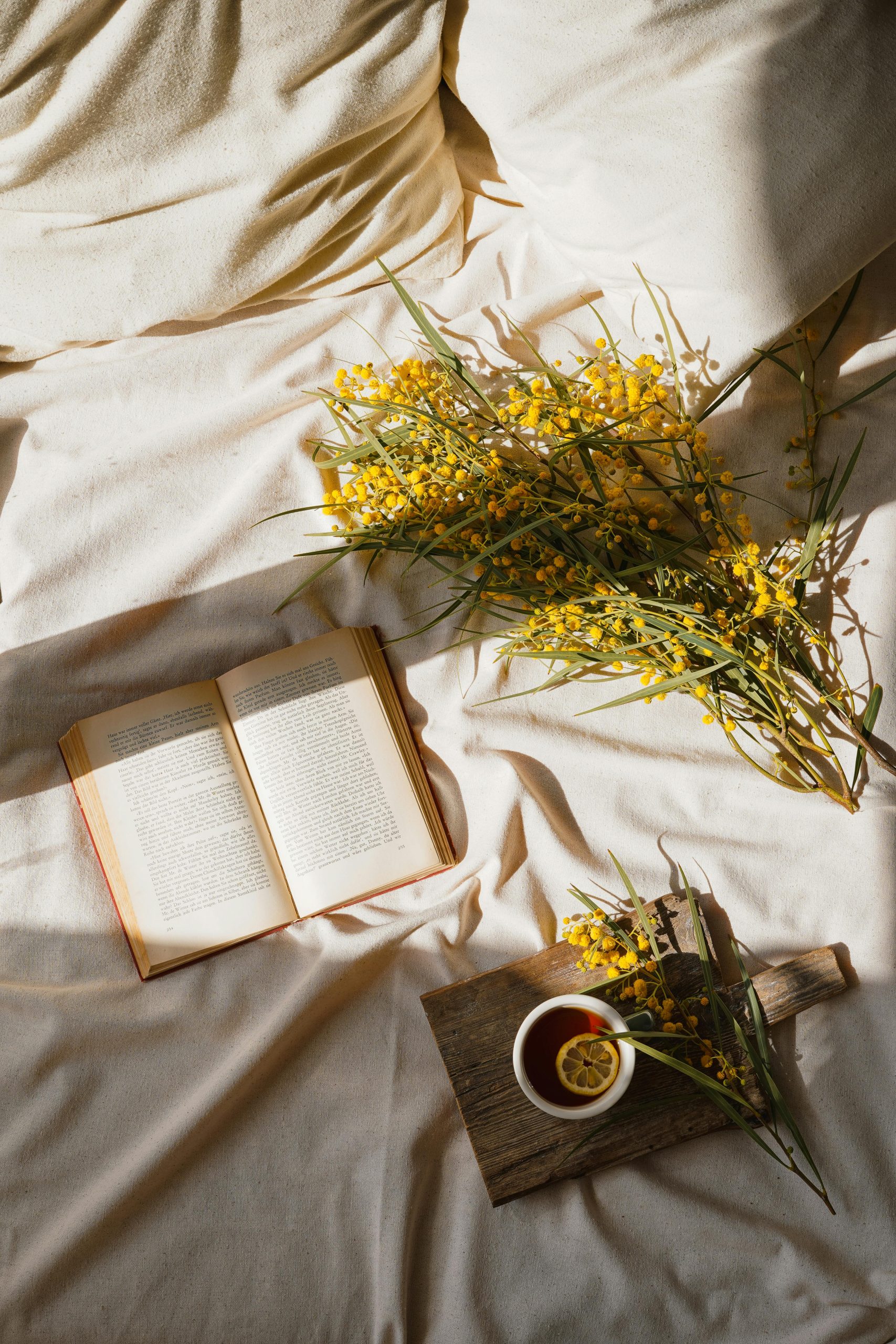 Sunday reset, book , flowers, and tea in a cozy bed
