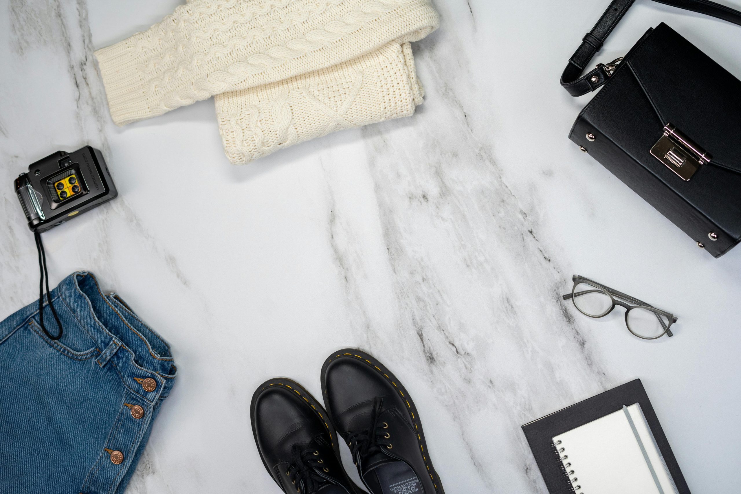 Flatlay with denim, oversized sweater and boots—foundation of a cozy fall outfit routine